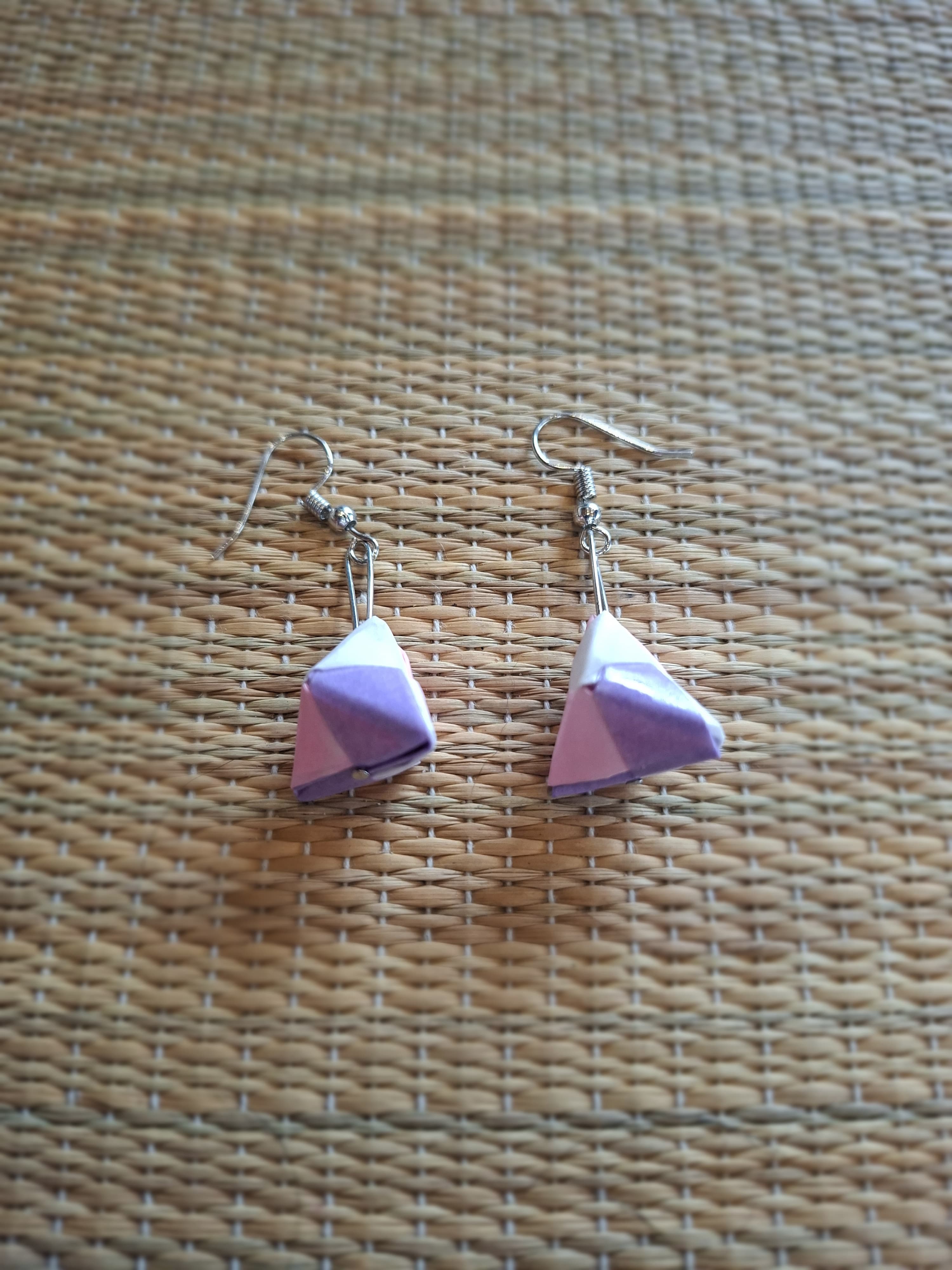 Purple and white origami diamond earrings on a woven background